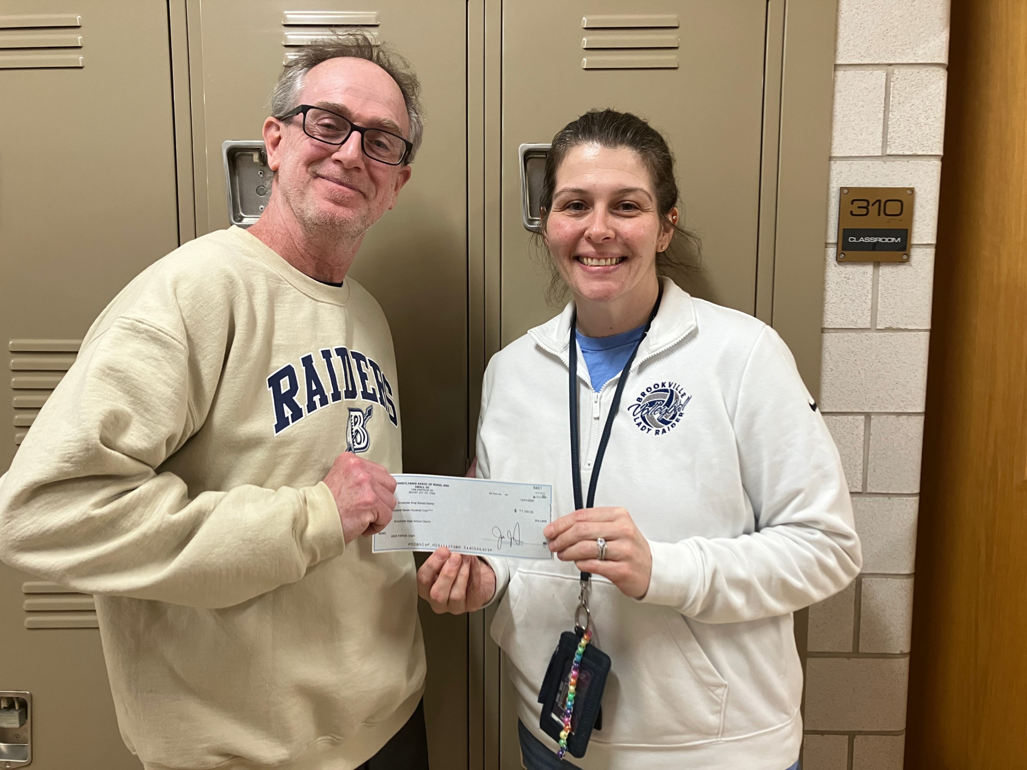 High school principal Shawn Deemer and math teacher Amber Siar pose for a photo with the grant check she was awarded from PARSS.